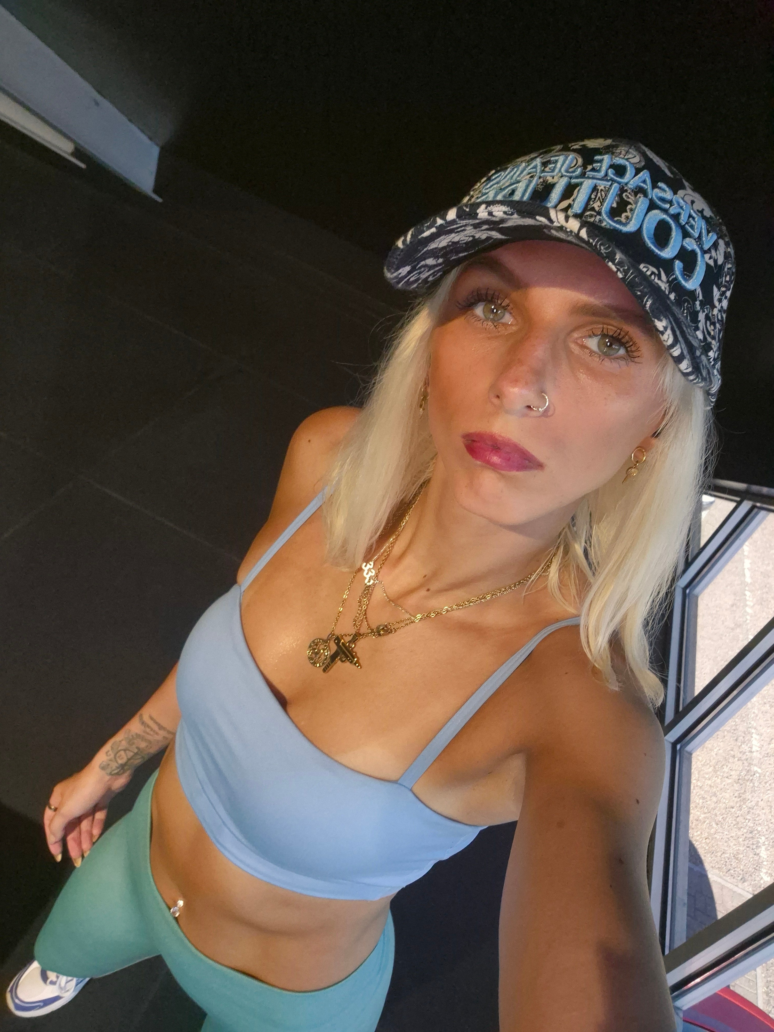 Emma at night wearing a designer cap and gold chains